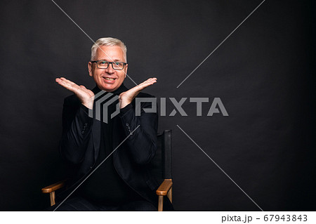 Emotional middle-aged man shrug. a middle aged man with white hair spreads his hands around his face in an emotional gesture Emotional middle-aged man shrug. a middle aged man with white hair spreads his hands around his face in an emotional gesture 67943843