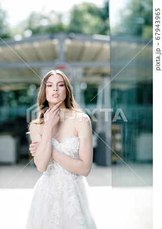 Beauty portrait of bride wearing fashion wedding dress with feathers with luxury delight make-up and hairstyle Beauty portrait of bride wearing fashion wedding dress with feathers with luxury delight make-up and hairstyle 67943965