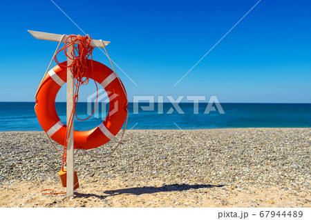 Lifebuoy on the beach against the sea Lifebuoy on the beach against the sea 67944489