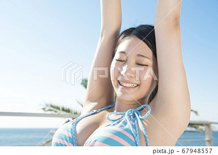 ビーチチェアに座る水着女性の写真素材