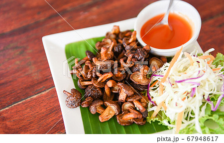 Delicious fried mushrooms in plate on wooden Delicious fried mushrooms in plate on wooden 67948617