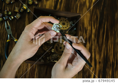 Girl craftsman dismantles watches. 67949145