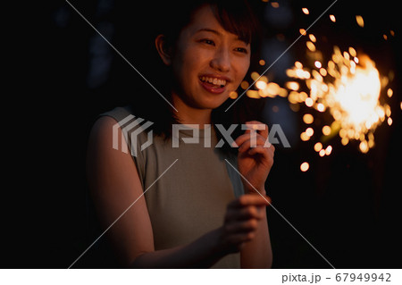 手持ち花火をする日本人女性の写真素材