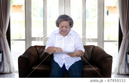 asian grandmother chating online with tablet 67950152