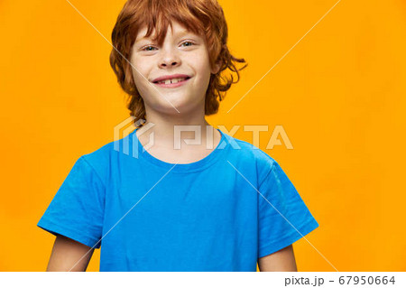 Little boy beautiful smile blue t-shirt yellow background red hair Little boy beautiful smile blue t-shirt yellow background red hair 67950664