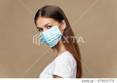 Young woman in white shirt in a protective mask Young woman in white shirt in a protective mask 67950779