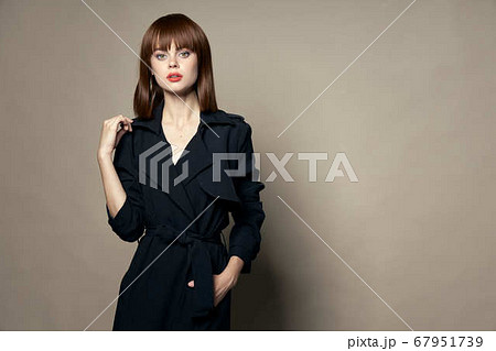 Woman in a black coat and bright makeup red hair free place Woman in a black coat and bright makeup red hair free place 67951739