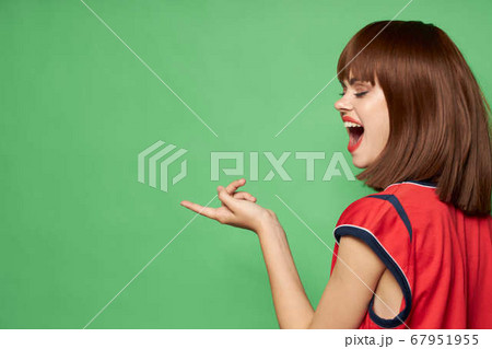 Woman with wide open mouth on a green background 67951955