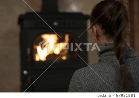 Portrait of pretty caucasian girl spending time in evening at home by fireplace Portrait of pretty caucasian girl spending time in evening at home by fireplace 67951981