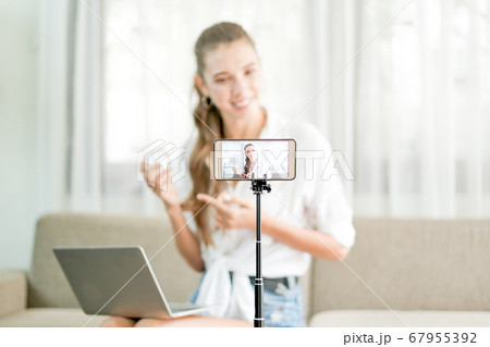 Beautiful woman with white shirt show and live review the cosmetic product in front the camera 67955392