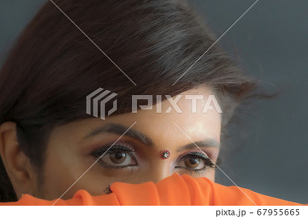 サリーを着たインド女性の目とビンディのクローズアップ 67955665