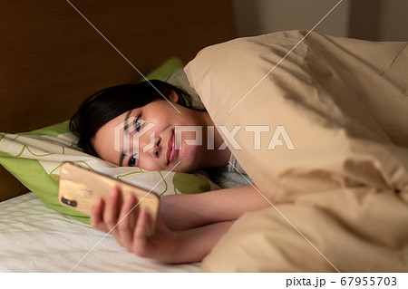 ベットでスマホを見る 67955703