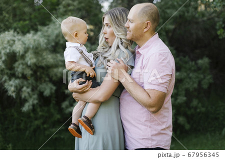 Parents with baby boy standing in garden Parents with baby boy standing in garden 67956345