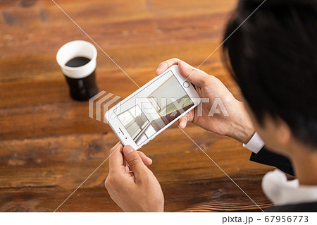 スマホで不動産物件を内見している人(オンライン内見イメージ) スマホで不動産物件を内見している人(オンライン内見イメージ) 67956773