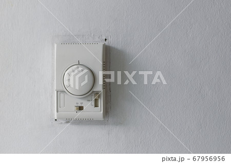 A white switch and termostat for controling air conditioner on the old white wall in patient room of a hospital in Bangkok A white switch and termostat for controling air conditioner on the old white wall in patient room of a hospital in Bangkok 67956956