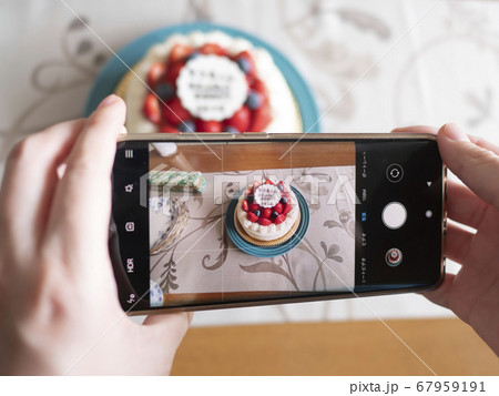 バースデーケーキをスマホカメラで撮影する女性 67959191