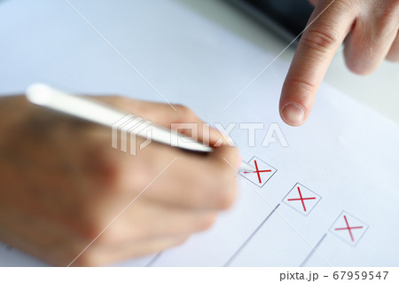 A man fills test columns with a red pen A man fills test columns with a red pen 67959547