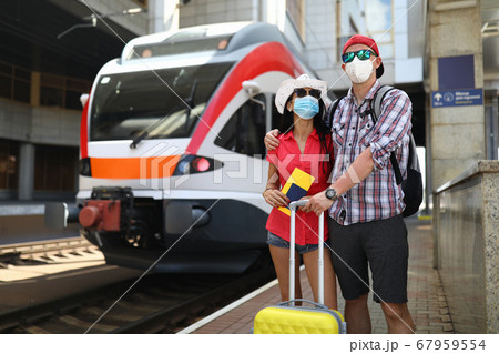 Family stands next to a train waiting for boarding 67959554