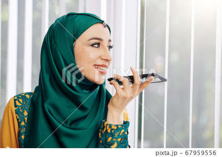 Muslim woman recording voice message Muslim woman recording voice message 67959556