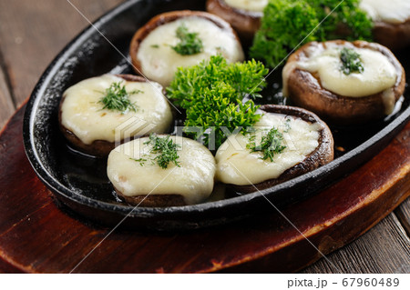Closeup on baked stuffed champignon hats Closeup on baked stuffed champignon hats 67960489