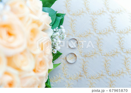 Beautiful wedding rings lie on light surface Beautiful wedding rings lie on light surface 67965870
