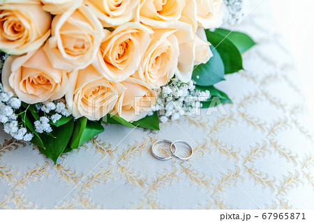 Beautiful wedding rings lie on light surface Beautiful wedding rings lie on light surface 67965871