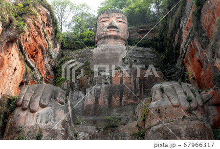 The Leshan Giant Buddha or Leshan Grand Buddha near Chengdu, Sichuan, China. The Leshan giant is the tallest stone Buddha statue in the world. View from a boat on the river near to Leshan and Chengdu. 67966317