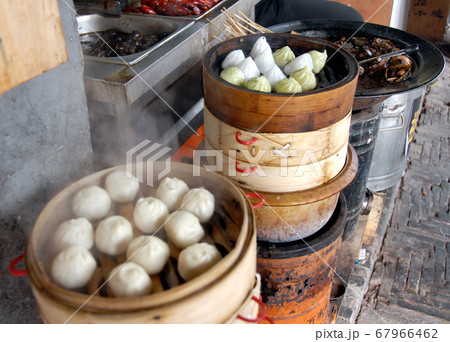 Chinese dumplings in Xitang water town near Shanghai. This is typical Chinese street food. These are steamed dumplings and are popular for lunch in China. Dumplings are a favorite Chinese food. Chinese dumplings in Xitang water town near Shanghai. This is typical Chinese street food. These are steamed dumplings and are popular for lunch in China. Dumplings are a favorite Chinese food. 67966462