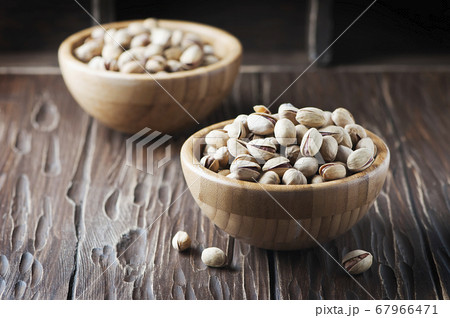 Salt pistachio nuts in the wooden bowl 67966471
