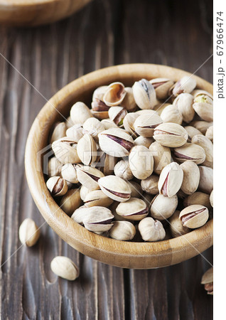 Salt pistachio nuts in the wooden bowl 67966474