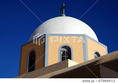 St John the Baptist Cathedral is a Roman Catholic church in Fira (Thira), Santorini, Greece. It is one of many churches in Fira, Santorini. The church has a white dome against a blue sky. Santorini. St John the Baptist Cathedral is a Roman Catholic church in Fira (Thira), Santorini, Greece. It is one of many churches in Fira, Santorini. The church has a white dome against a blue sky. Santorini. 67968413