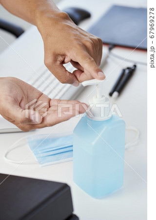 man at work disinfecting his hands man at work disinfecting his hands 67969278