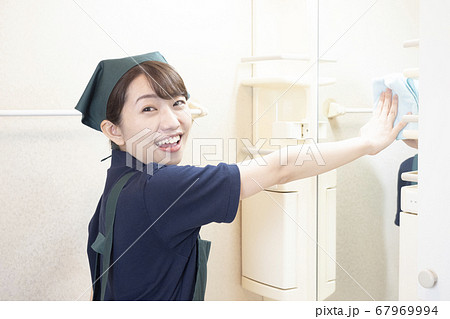 洗面所の鏡を拭くハウスクリーニングの女性作業員 67969994