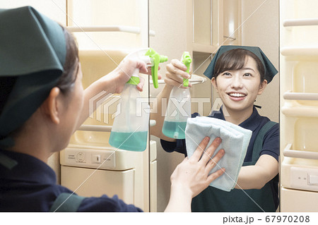 洗面所の鏡を拭くハウスクリーニングの女性作業員 67970208