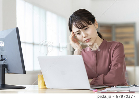 パソコンの画面を見ながら頭を抱える若い女性 パソコンの画面を見ながら頭を抱える若い女性 67970277