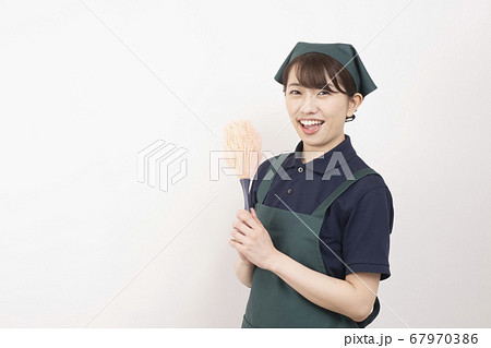 ピンクのハンディモップを持つ家事代行の女性作業員 ピンクのハンディモップを持つ家事代行の女性作業員 67970386