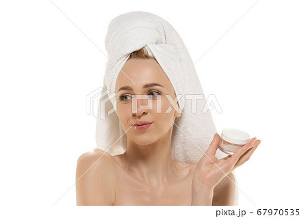 Beauty Day. Woman wearing towel doing her daily skincare routine. Portrait isolated on white studio background 67970535