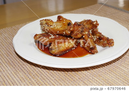 鶏手羽の唐揚げに醤油ベースの甘辛ソースを塗した料理 鶏手羽の唐揚げに醤油ベースの甘辛ソースを塗した料理 67970646