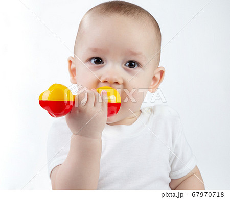 Portrait of a nine-month-old baby with rattle on a white background Portrait of a nine-month-old baby with rattle on a white background 67970718