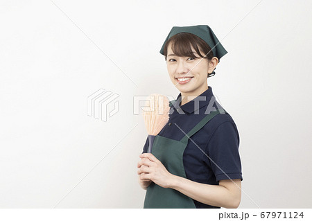 ピンクのハンディモップを持つ家事代行の女性作業員 67971124