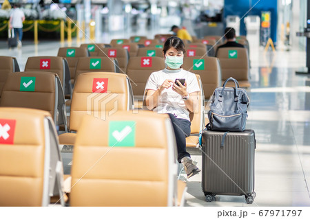 Young female wearing face mask and using mobile 67971797
