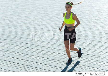 Female runner, athlete training outdoors in summer's sunny day. 67972364