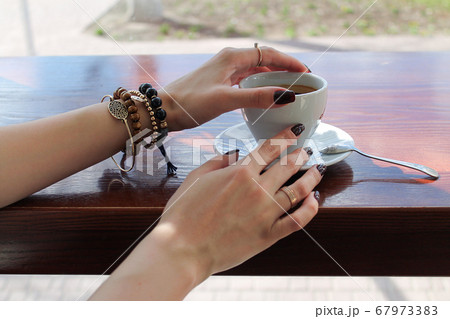 Woman holding cup of coffee for breakfast	 67973383