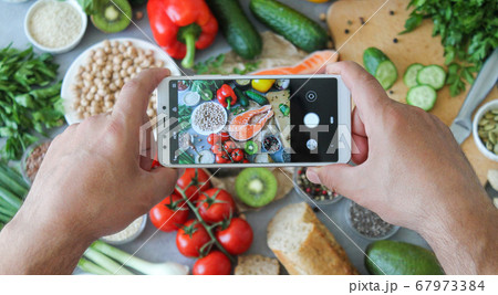 Man photographing food ingredients for balanced healthy diet	 67973384