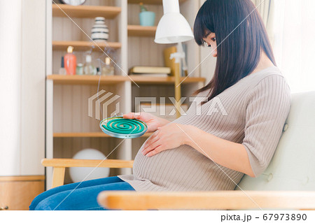 蚊取線香　妊婦　煙　燻る　コピースペース　 67973890