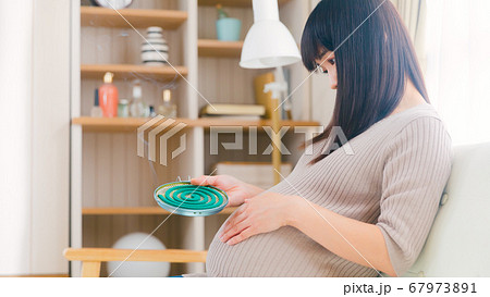 蚊取線香　妊婦　煙　燻る　コピースペース　16:9 67973891