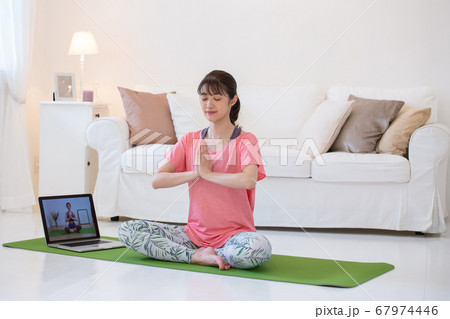 自宅でヨガをする若い女性 オンラインフィットネス 自宅でヨガをする若い女性 オンラインフィットネス 67974446