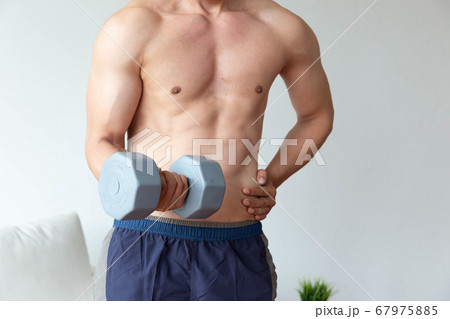 Athletic young man doing exercise with dumbbell in 67975885