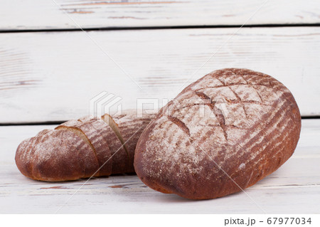 Bread with flour on wooden background. Bread with flour on wooden background. 67977034