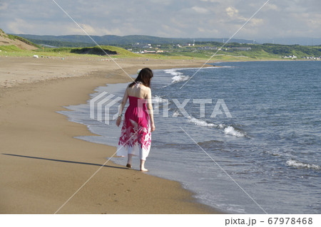 夏の北海道江差町の海岸でピンクのフラの衣装で女性のポートレートを撮影 67978468